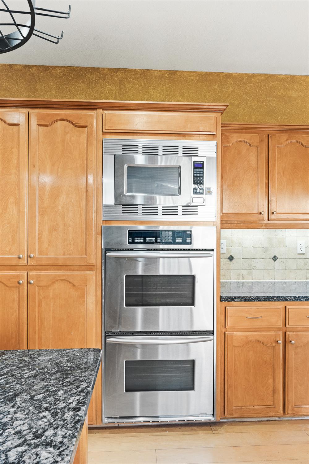 783 Bodega Avenue Lemoore, CA 93245 - Photo 13 of 35 a kitchen with granite countertop cabinets and steel stainless steel appliances