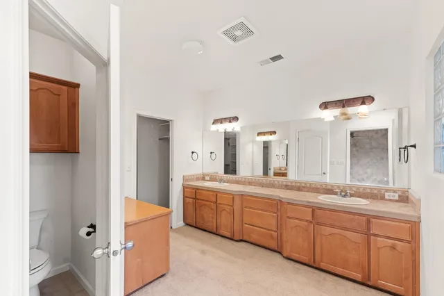 a spacious bathroom with a double vanity sink a mirror and a bathtub