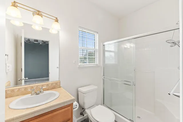 a bathroom with a sink a toilet and shower