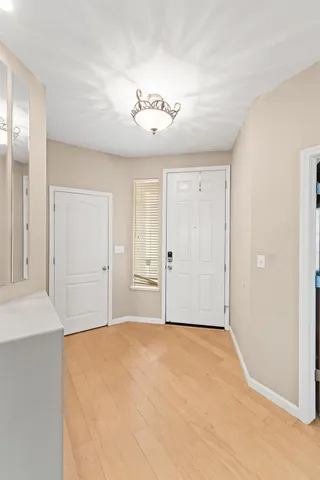 a view of an empty room with a chandelier fan