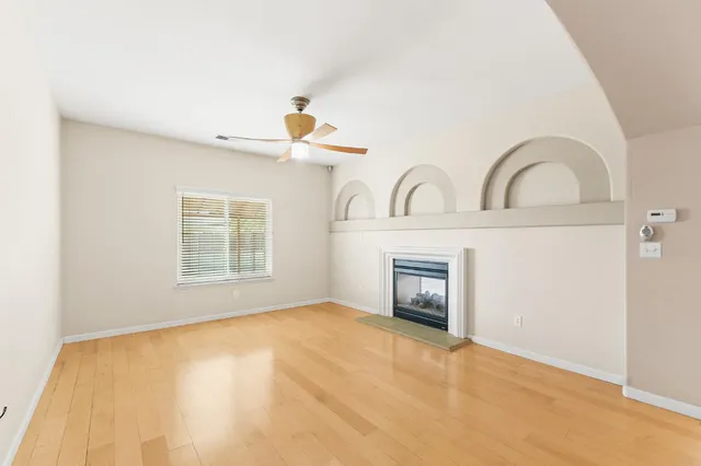 a view of an empty room with a fireplace and a window
