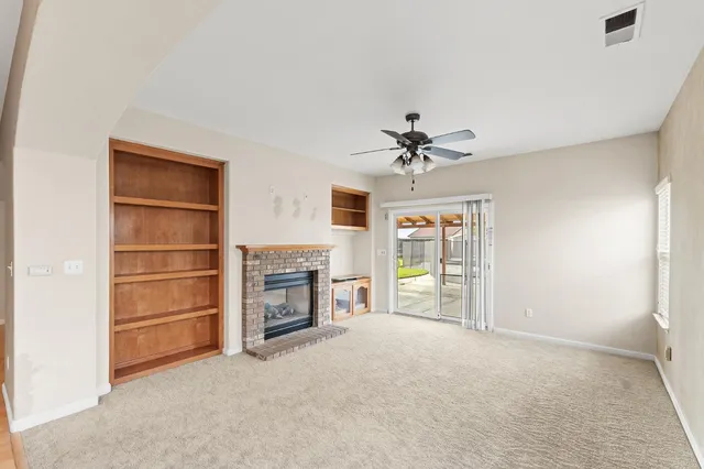 a view of an empty room with a window and a kitchen