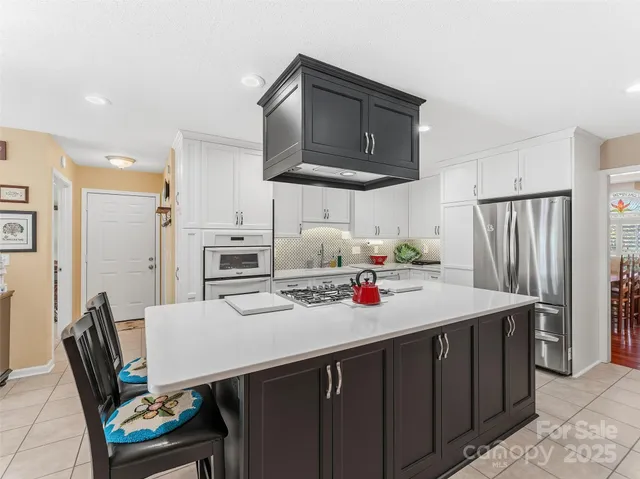 a kitchen with stainless steel appliances a stove a sink dishwasher and a refrigerator with wooden cabinets