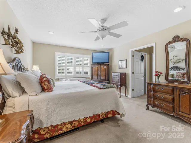 a bedroom with a large bed and a chandelier