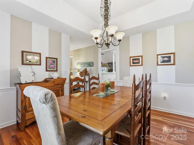 a view of a dining room with furniture a chandelier and wooden floor