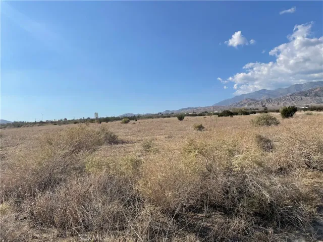 a view of a dry yard with mountains in the background