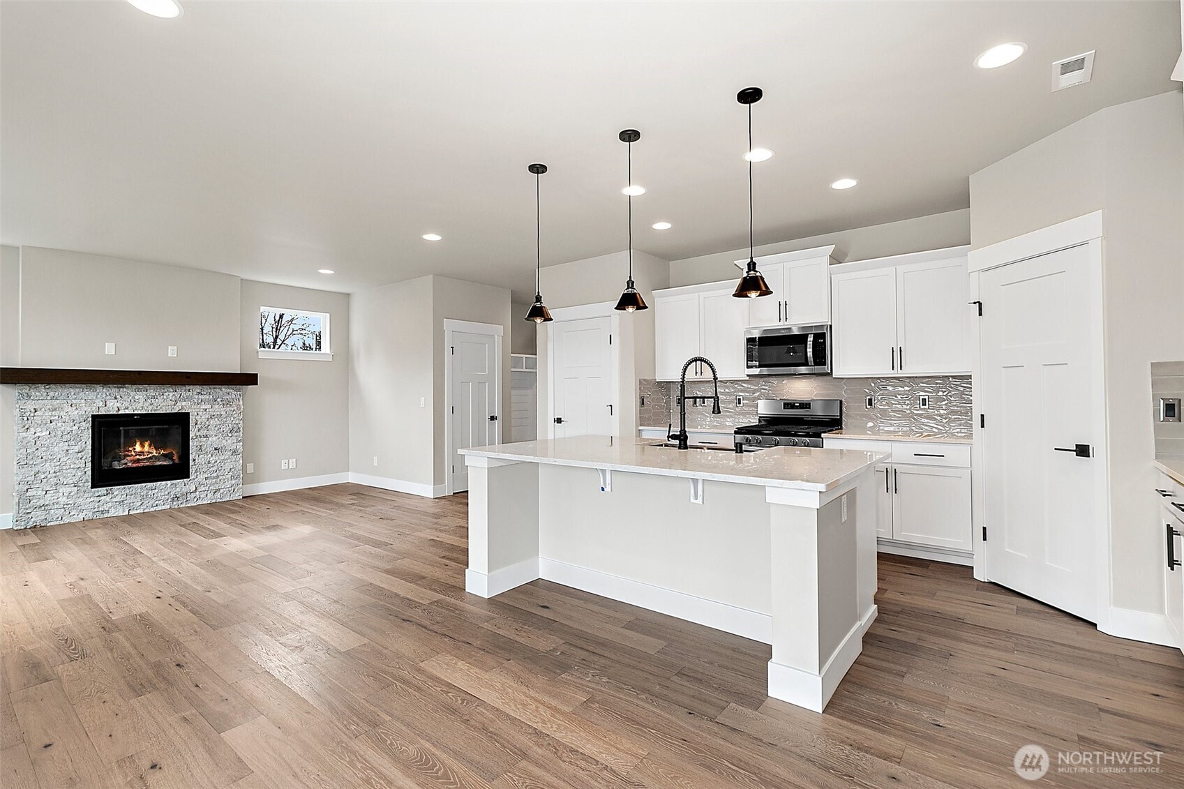 18510 Meridian Avenue Southeast, Unit CR 02 Bothell, WA 98012 - Photo 14 of 31 a kitchen with stainless steel appliances kitchen island granite countertop a stove a sink a refrigerator and a fireplace with wooden floor