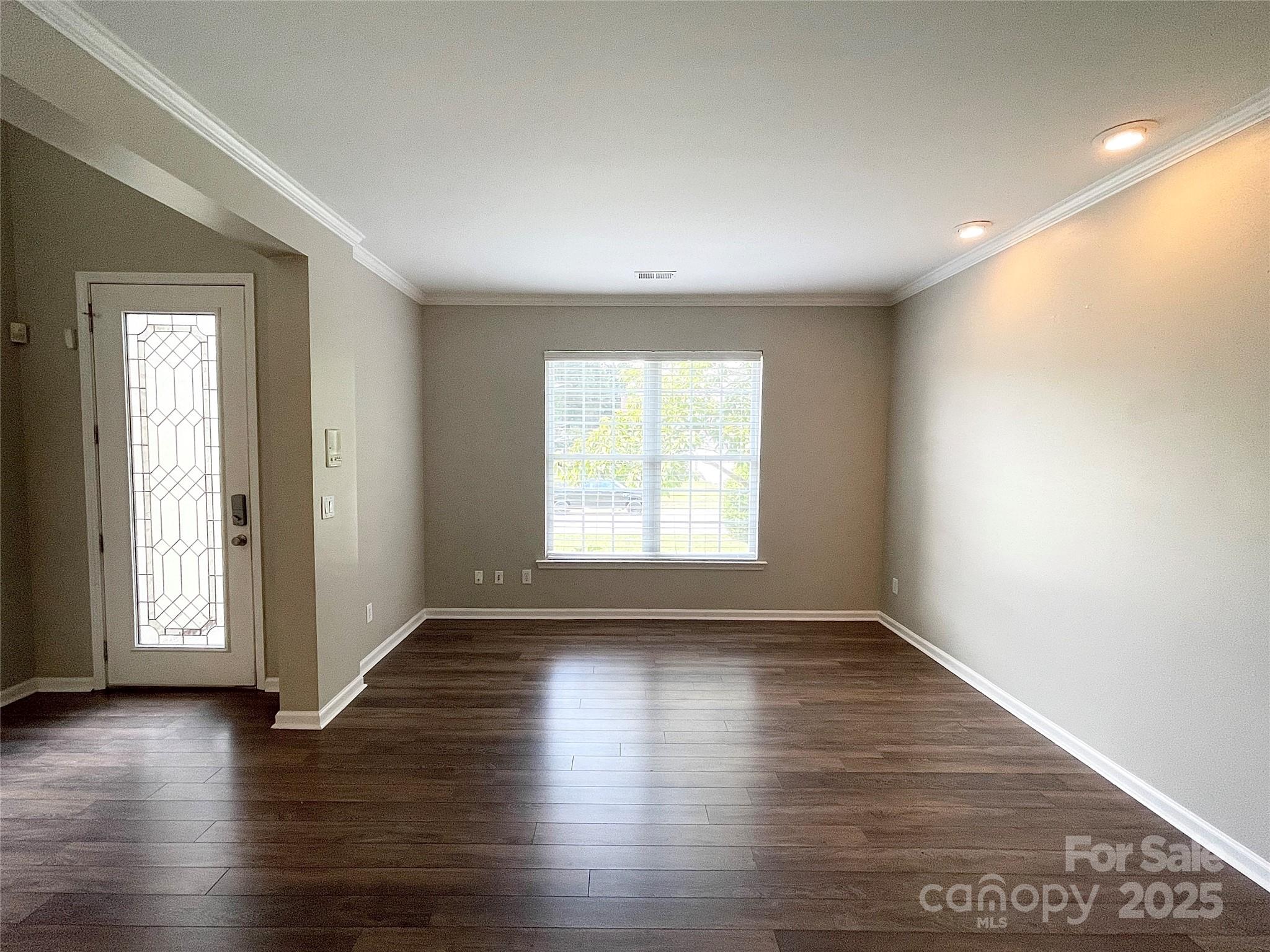 2834 Ritz Lane Matthews, NC 28105 - Photo 6 of 32 an empty room with wooden floor and windows with curtains view