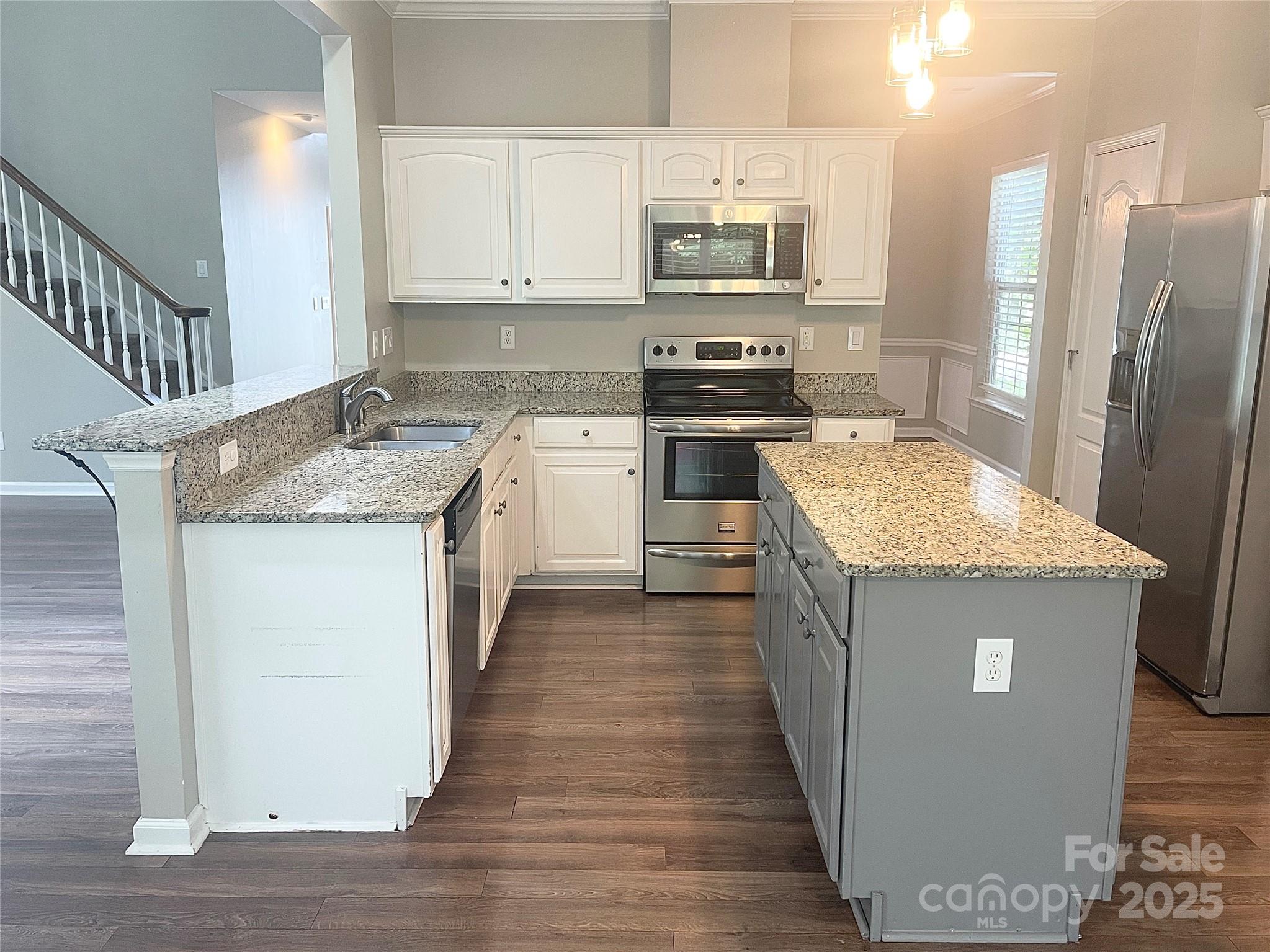 2834 Ritz Lane Matthews, NC 28105 - Photo 9 of 32 a kitchen with stainless steel appliances granite countertop a kitchen island a stove a refrigerator a sink and dishwasher with wooden floor