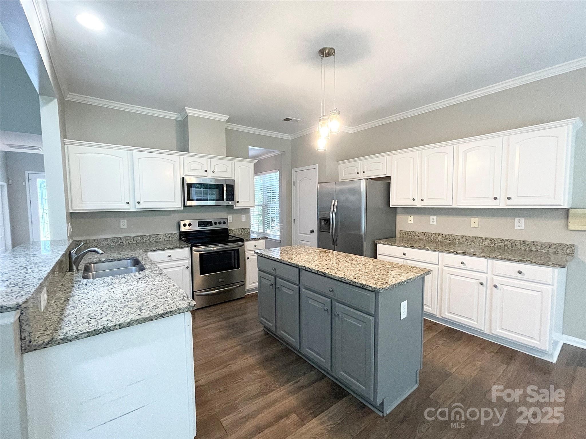 2834 Ritz Lane Matthews, NC 28105 - Photo 10 of 32 a large kitchen with granite countertop a stove top oven a sink a counter space and cabinets