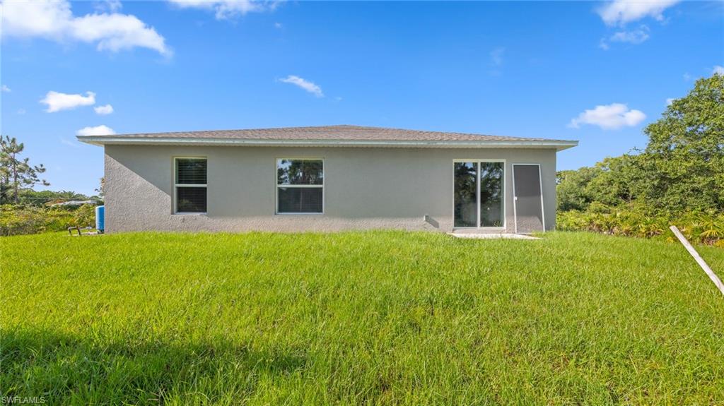 156 Peerless Street Lehigh Acres, FL 33974 - Photo 26 of 26 a house view with a garden space
