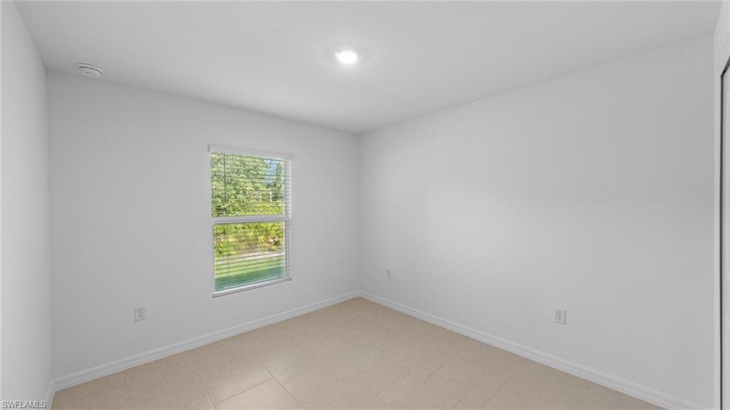 156 Peerless Street Lehigh Acres, FL 33974 - Photo 4 of 26 an empty room with a window