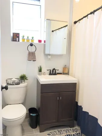a bathroom with a sink mirror vanity and toilet
