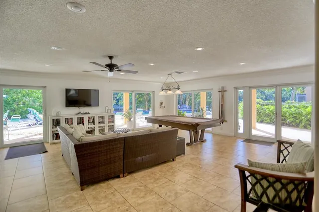 a living room with furniture a flat screen tv and a large window
