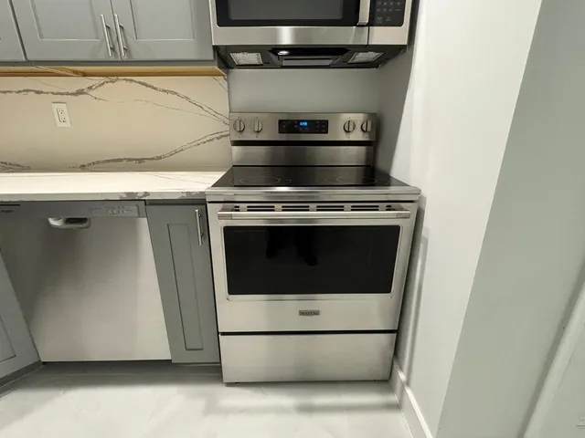 a stove top oven sitting inside of a kitchen
