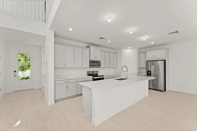 a kitchen with white cabinets and stainless steel appliances