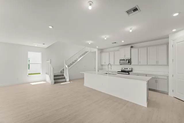 a kitchen with stainless steel appliances kitchen island sink and refrigerator