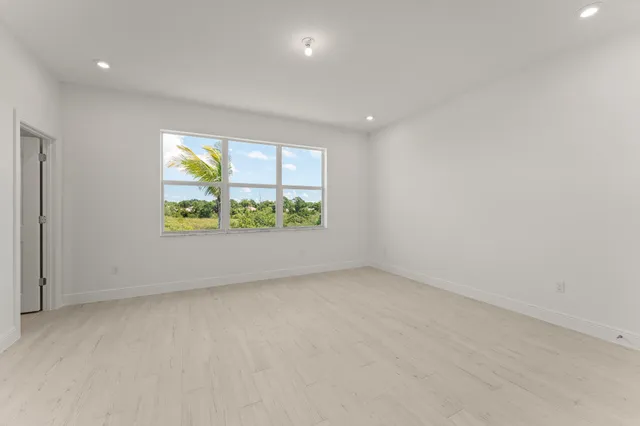 an empty room with window & wooden floor