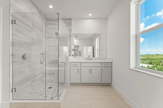 a bathroom with a granite countertop sink a shower a mirror and a bathtub