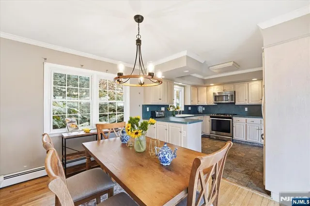 a view of a dining room and livingroom with furniture wooden floor a chandelier