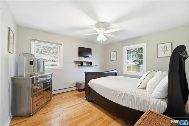 a bedroom with a bed flat screen tv and window