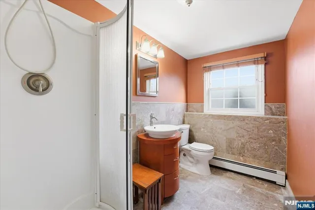 a bathroom with a toilet a sink and a mirror