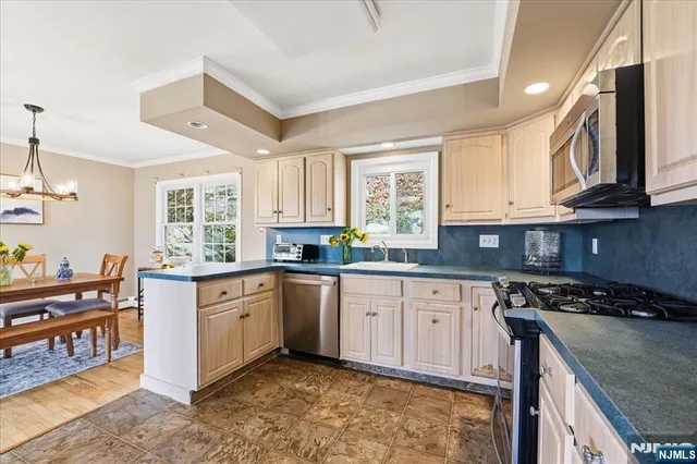 a kitchen with stainless steel appliances granite countertop a stove a sink dishwasher and cabinets with wooden floor