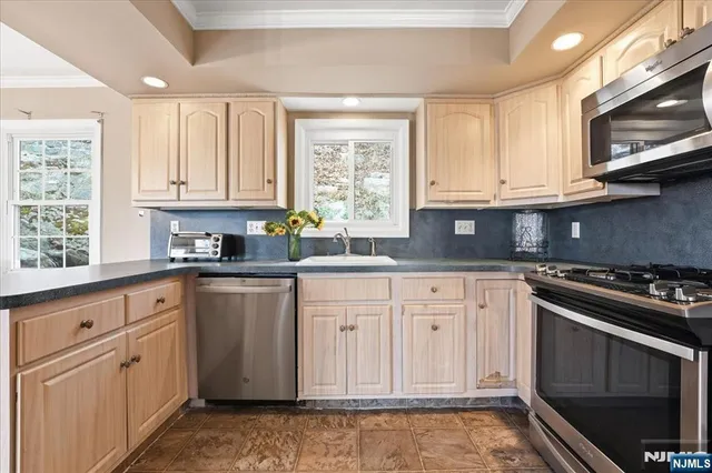 a kitchen with granite countertop white cabinets and stainless steel appliances