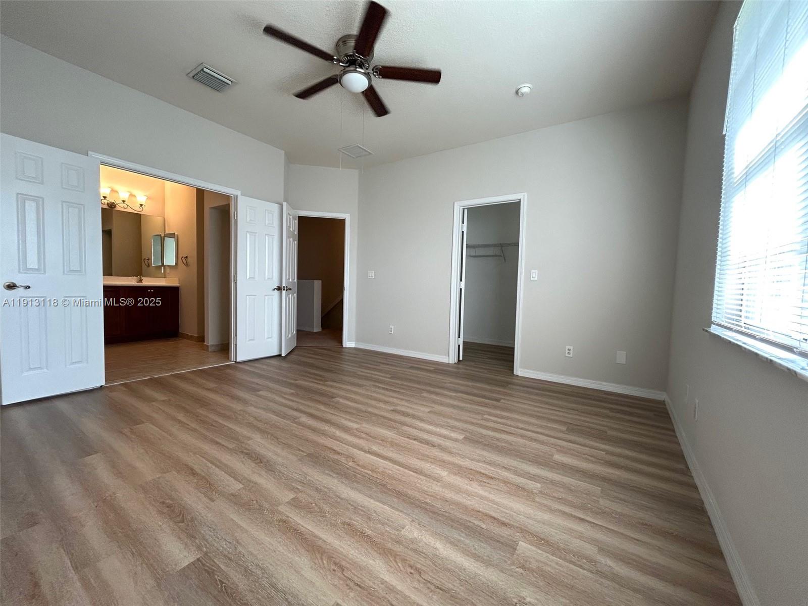 1560 Southeast Wilshire Place, Unit 103 Stuart, FL 34994 - Photo 20 of 33 an empty room with wooden floor and windows