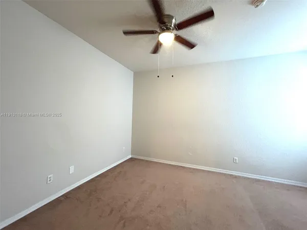 an empty room with a empty space and a ceiling fan