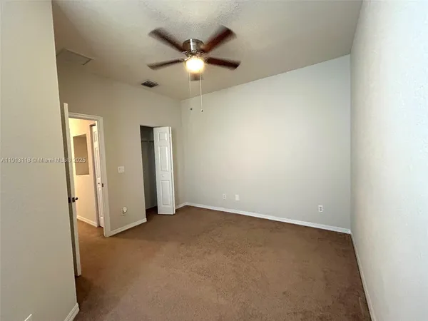 an empty room with chandelier fan
