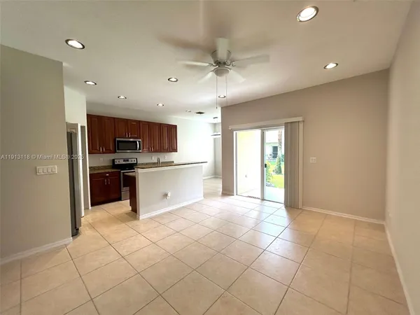 a large kitchen with stainless steel appliances granite countertop a refrigerator and a stove top oven