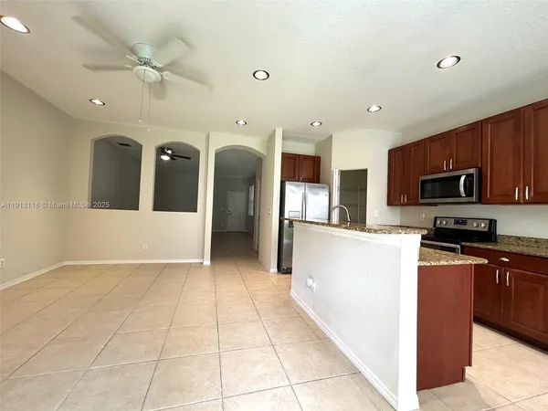 a kitchen with stainless steel appliances granite countertop a refrigerator and a stove top oven