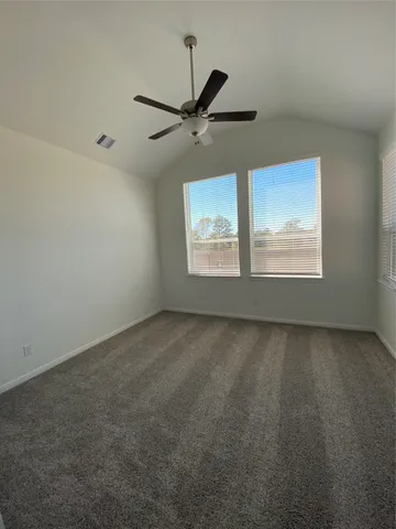 an empty room with windows and fan