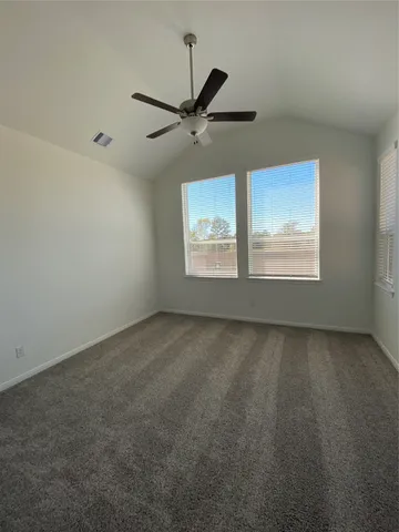 an empty room with windows and fan