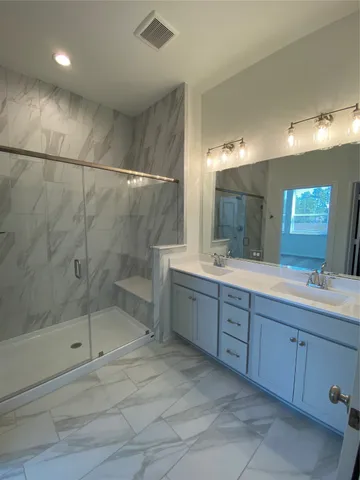 a bathroom with a sink mirror and a shower