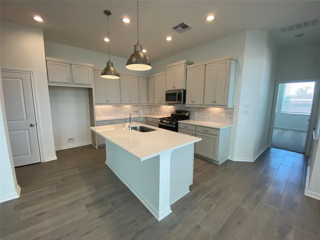 a kitchen with kitchen island cabinets and wooden floor