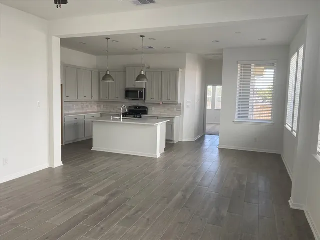 a kitchen with a sink cabinets and wooden floor