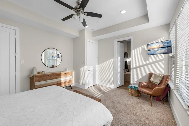 a bedroom with a bed a mirror and a chandelier