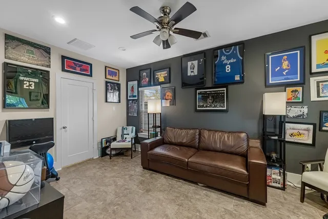 a living room with furniture and a ceiling fan