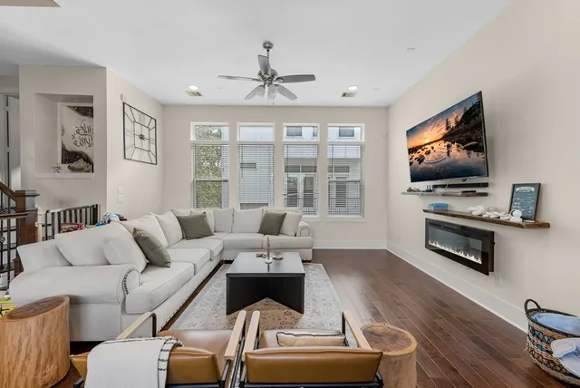 a living room with furniture a flat screen tv and a large window