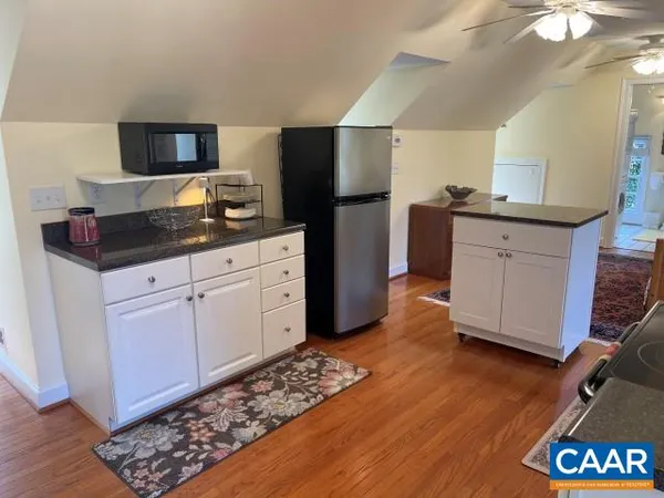 a kitchen with granite countertop a refrigerator and a sink