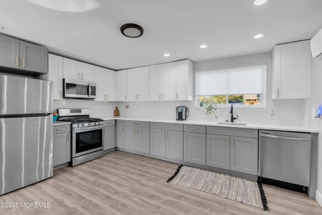 a kitchen with granite countertop a stove a sink and a refrigerator