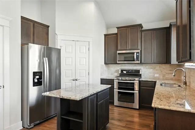 a kitchen with granite countertop a stove microwave and sink