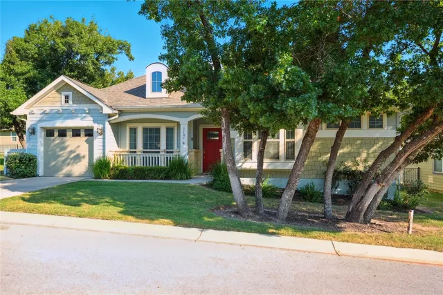 a front view of a house with a yard and potted plants