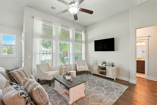 a living room with furniture a flat screen tv and a large window