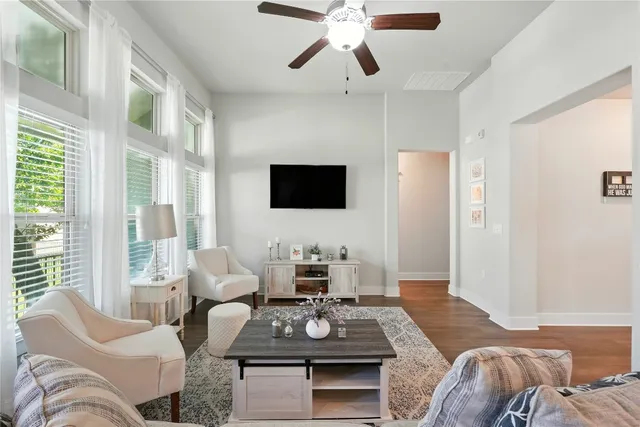 a living room with furniture a flat screen tv and a large window