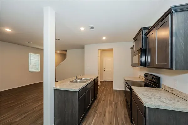 a kitchen with stainless steel appliances granite countertop a stove refrigerator and wooden floor