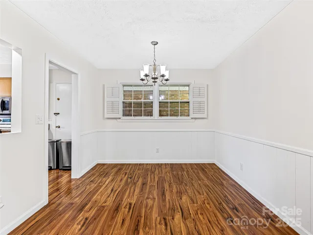 a view of a kitchen with wooden floor and a large window