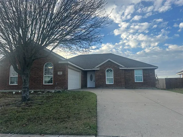 a front view of house with yard and trees in the background